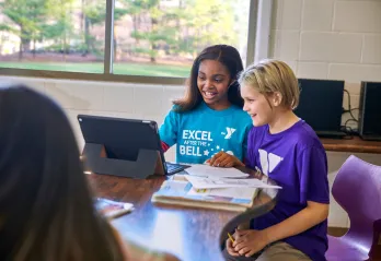 two kids reading and working on computer