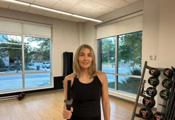 The featured member, Kristen, is pictured in a studio at the Bear Levin Studer Y before working out.