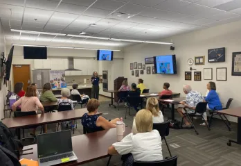 Volunteers for the Y Reads program fill the Gulf Power Room as the Y Reads Director Rebecca presents information about the program.