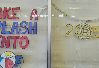 A window in the aquatic center at BLS is painted to read "Make a splash into 2025."