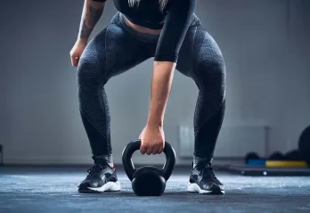 A photo shows a woman working out with a kettlebell.