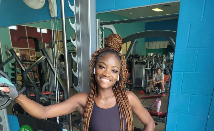 Kenani, a member at the Betty J. Pullum YMCA, poses for a photo near the weights.