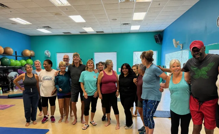 Members in a group exercise class at the Betty J. Pullum Y pose together in a line for a photo.