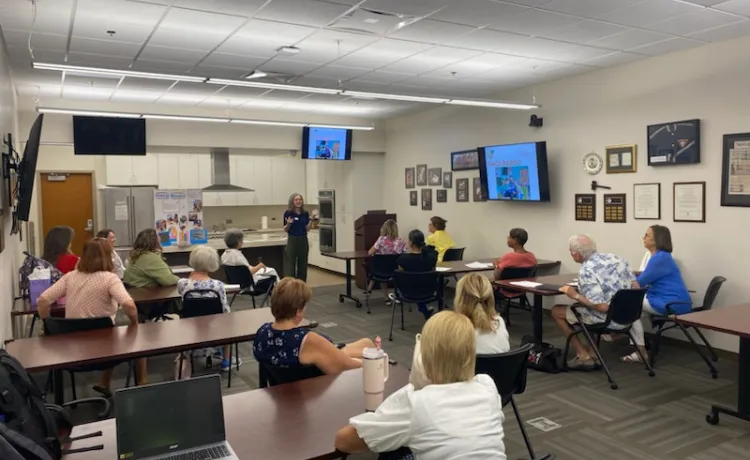 Volunteers for the Y Reads program fill the Gulf Power Room as the Y Reads Director Rebecca presents information about the program.