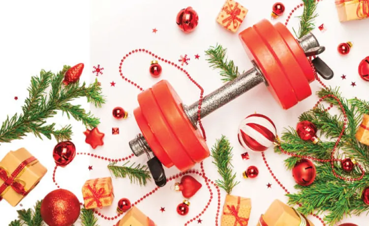 A weight is pictured alongside holiday trimmings such as garland, gifts, and Christmas tree ornaments.