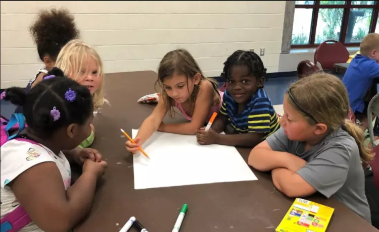 A group of children work together on an art project in a child care program at the Northeast YMCA.