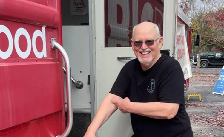 Member stands outside OneBlood bus.