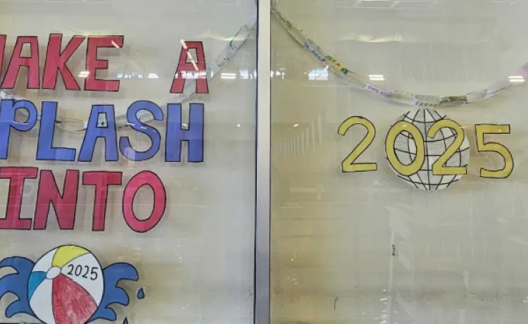 A window in the aquatic center at BLS is painted to read "Make a splash into 2025."