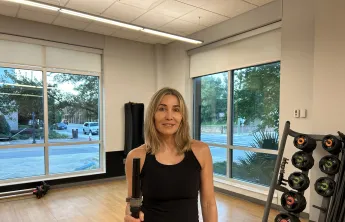 The featured member, Kristen, is pictured in a studio at the Bear Levin Studer Y before working out.