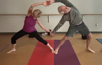 man and woman do yoga pose